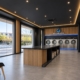 Interior de lavandería autoservicio Riowash con maquinaria profesional, madera y detalles de luz azul